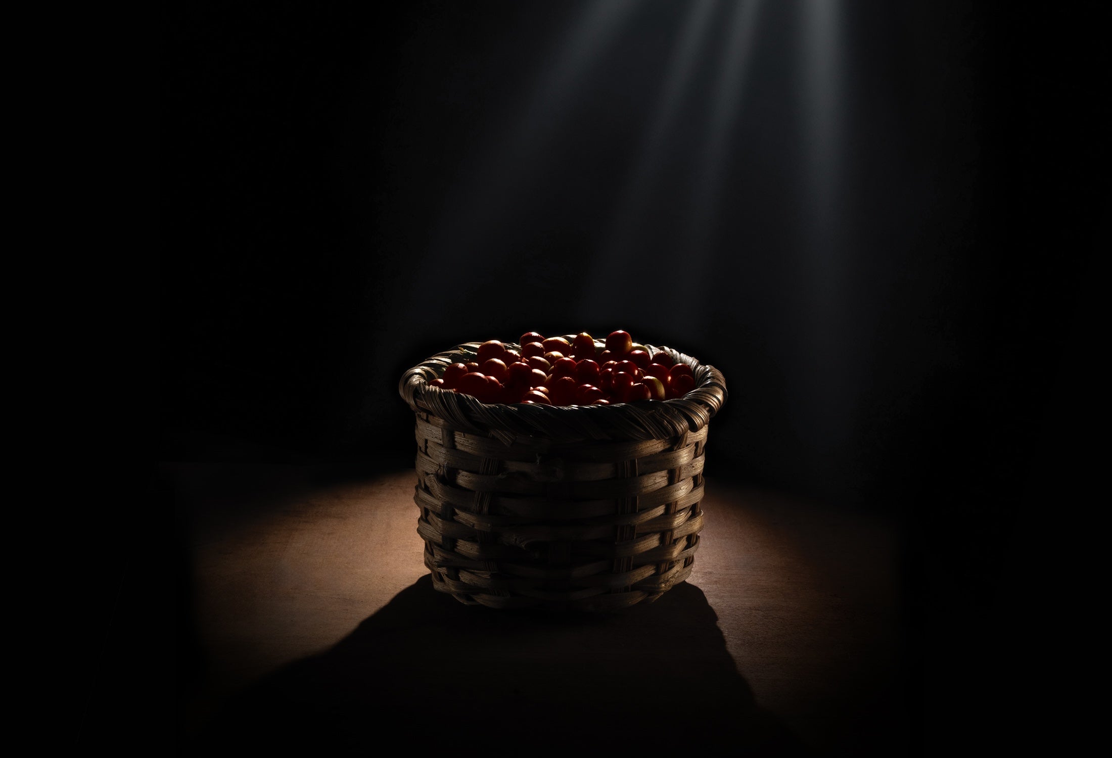 Una canasta con fruta de café en un cuarto oscuro
