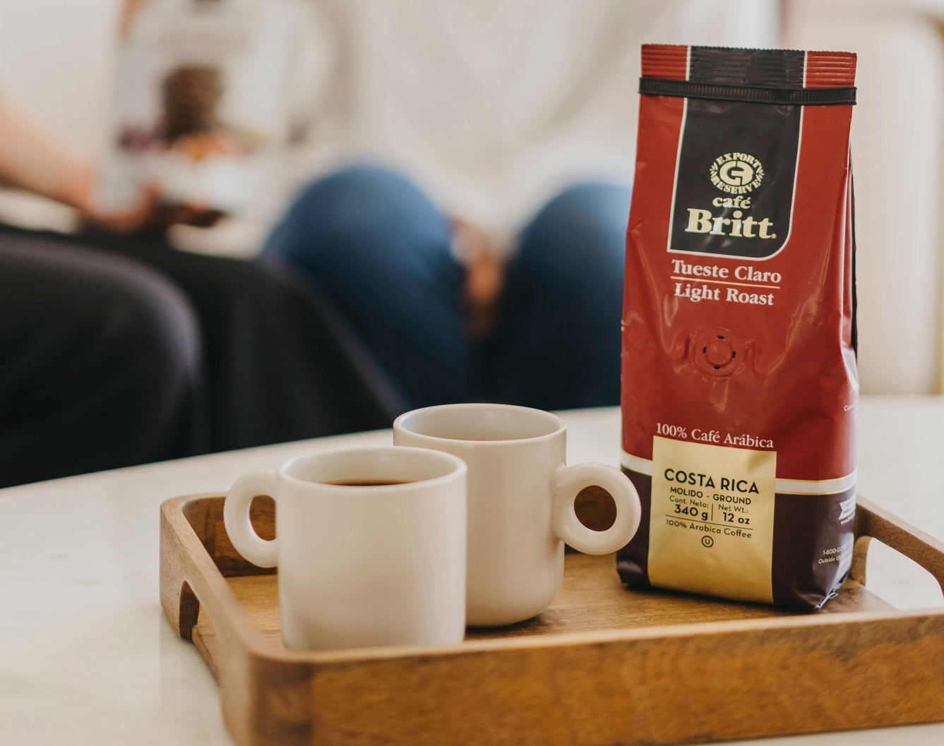 Bolsa de café Britt Tueste Claro junto a una taza de café recién preparado.