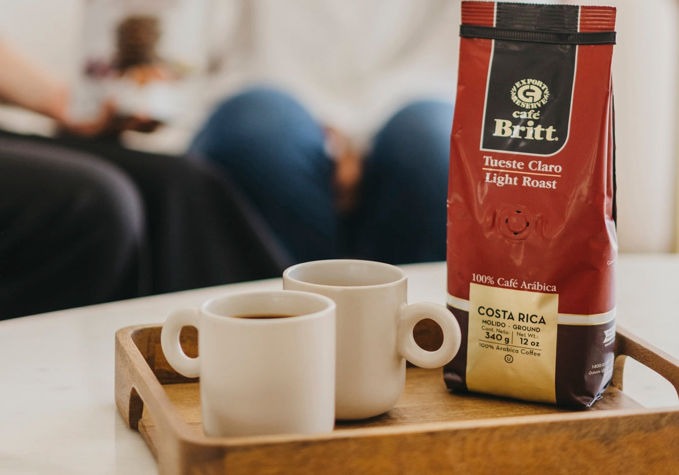 Bolsa de café Britt Tueste Claro junto a una taza de café recién preparado.
