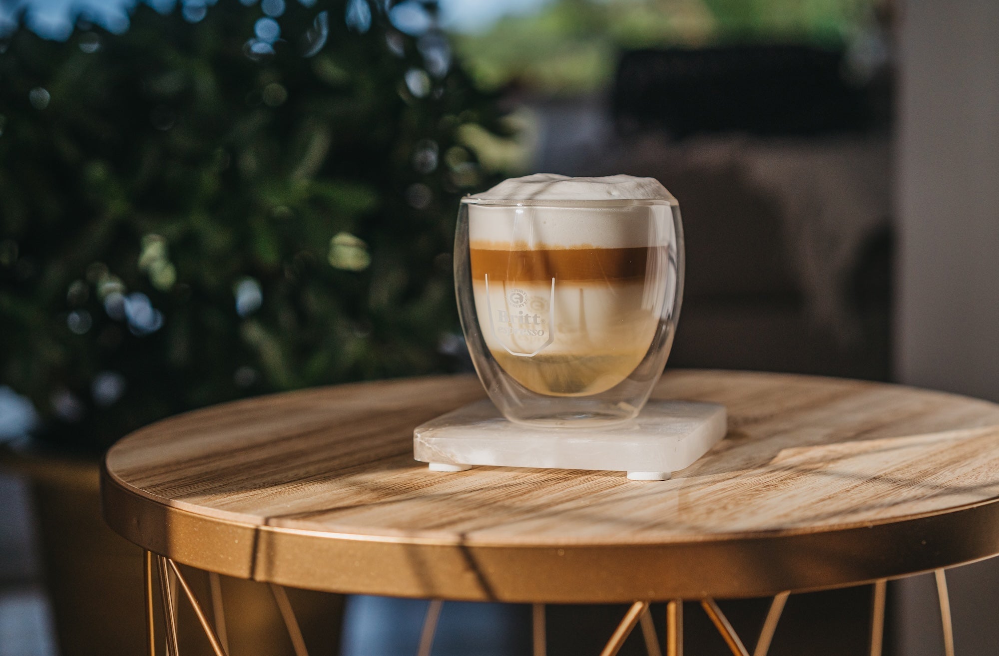 Cappuccino de avellana con espuma de leche servido en taza de vidrio.