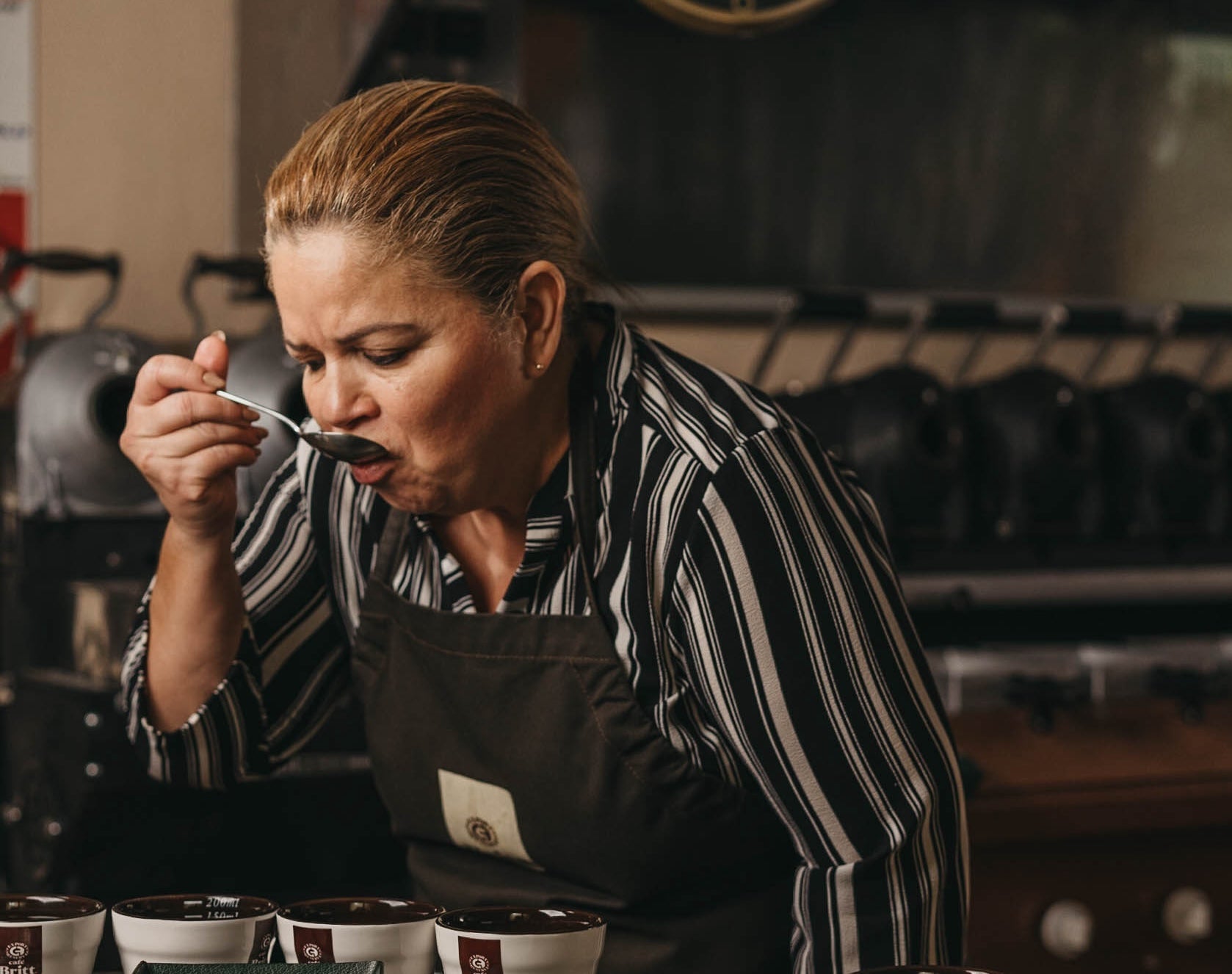 Maestra catadora degustando una taza de café durante una sesión de cata.