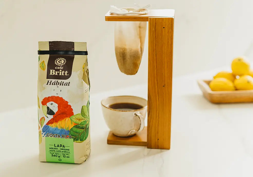 Taza de café preparada al estilo costarricense junto a café Café Britt 