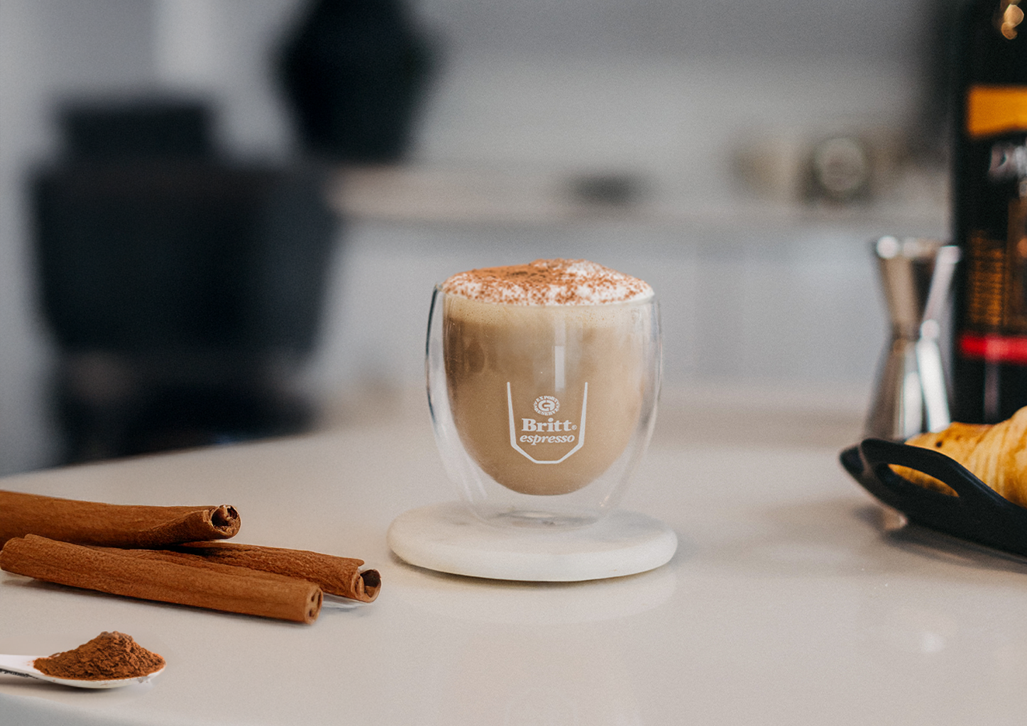 Mocha caliente con canela servido en taza de vidrio, preparado con café espresso.