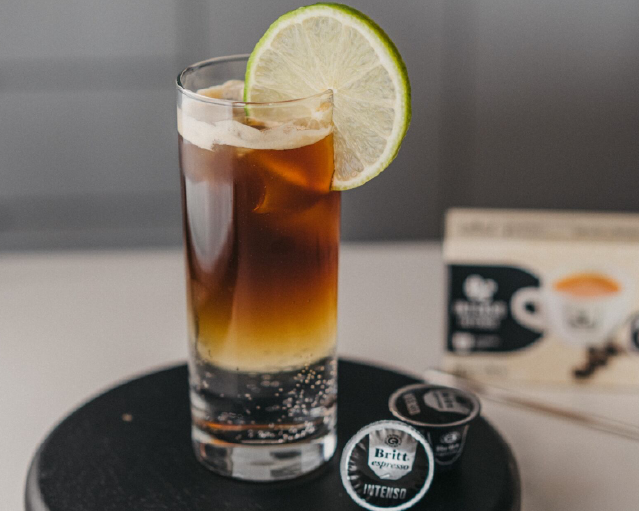 Espresso tonic servido con hielo y rodaja de limón.