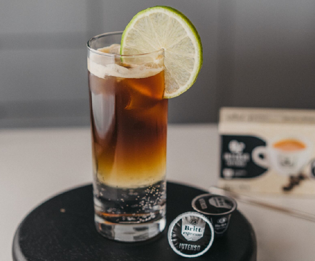 Espresso tonic servido con hielo y rodaja de limón.