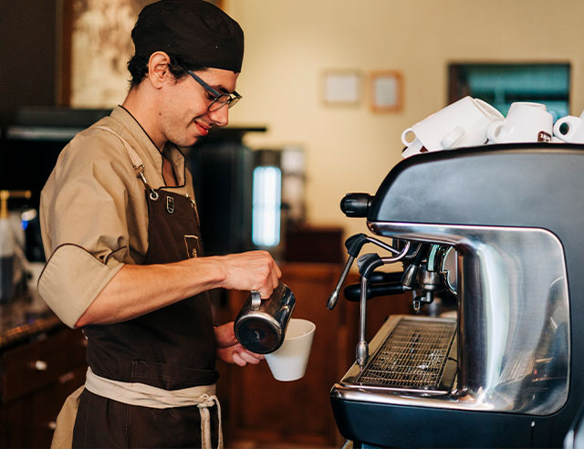 Man steaming milk at an espresso machine